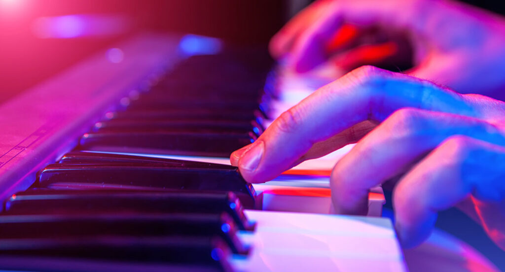 Closeup photo of hands on piano keys.